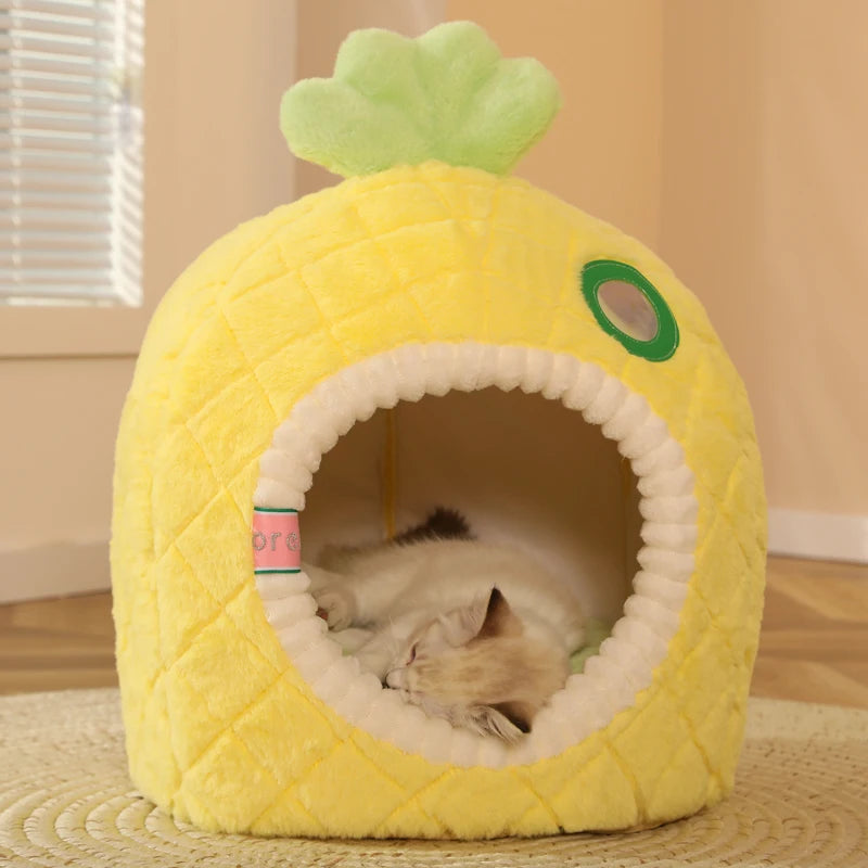 Yellow pineapple-shaped cat bed with a cat inside on a wooden floor.