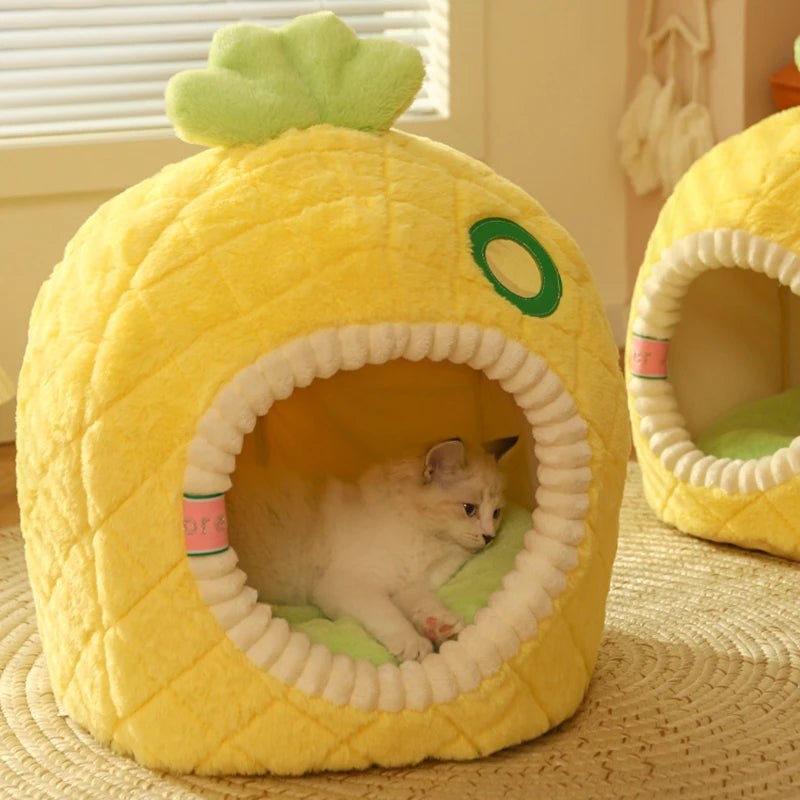 Cat lying inside a pineapple-shaped cat bed on a textured surface.