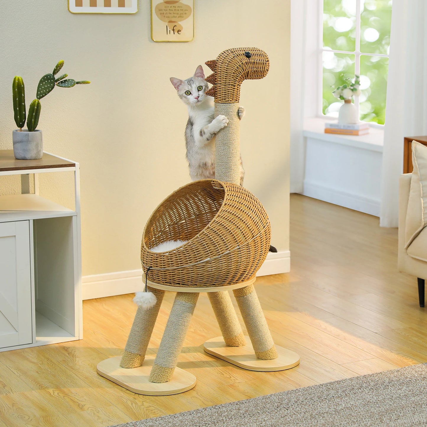 Cat playing on a dinosaur-shaped wicker cat tree in a room with a window and furniture.