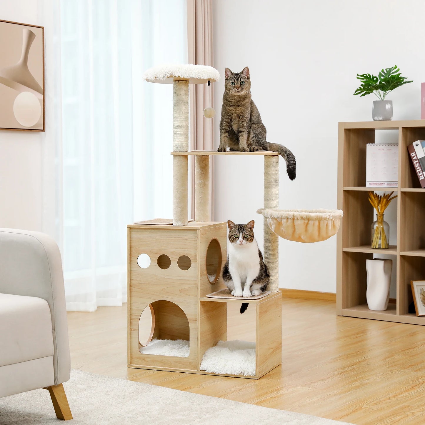 Two cats sitting on a wooden cat tree in a living room setting.