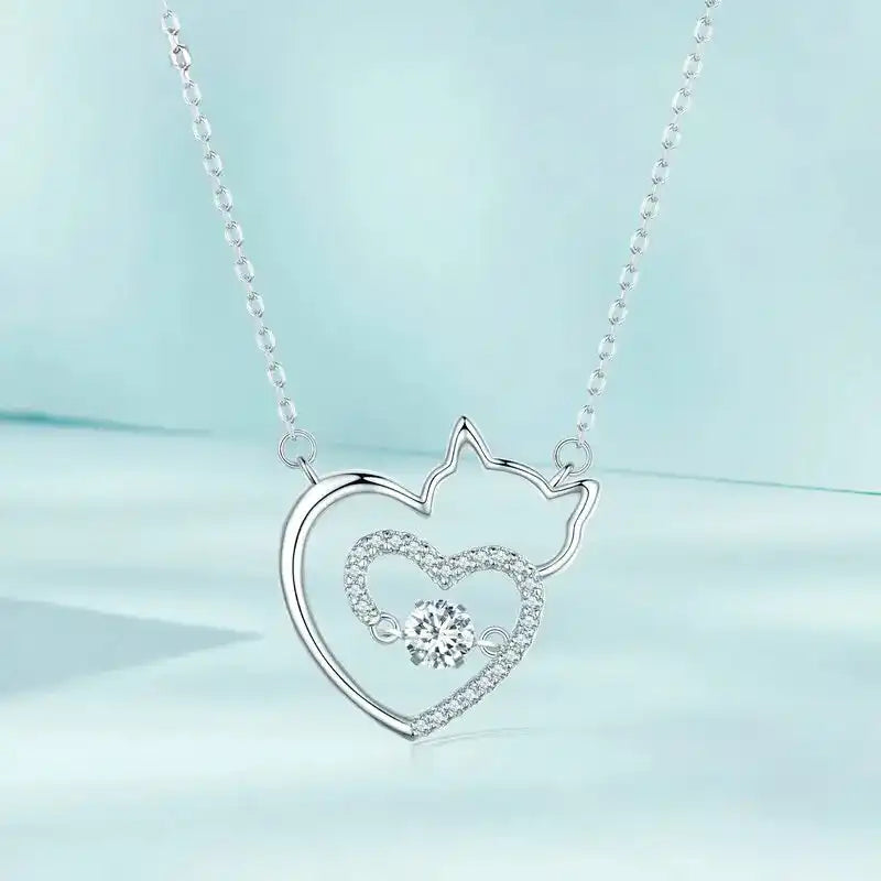 Silver necklace with a heart-shaped pendant featuring a cat design on a light blue background