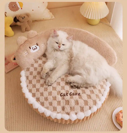 White cat lying on a checkered pet bed with cat ears in a cozy room.