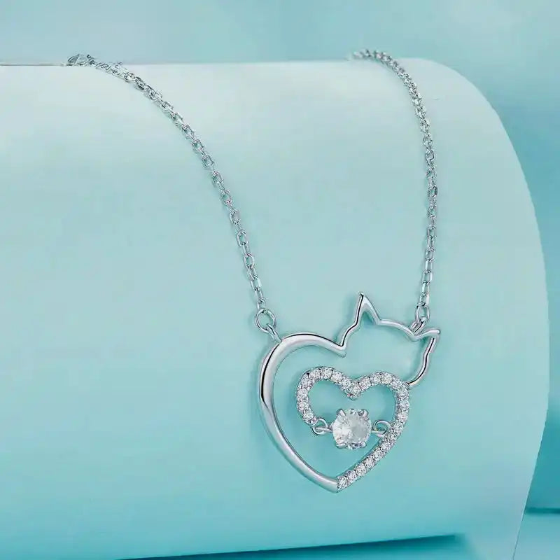 Silver necklace with a heart-shaped pendant on a light blue background