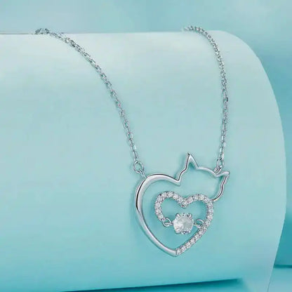 Silver necklace with a heart-shaped pendant on a light blue background