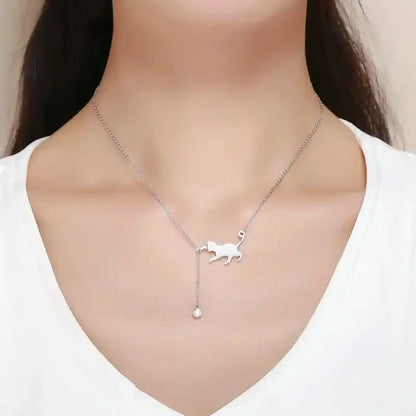 Silver necklace with cat-shaped pendant and cubic zirconia shown on a model. 