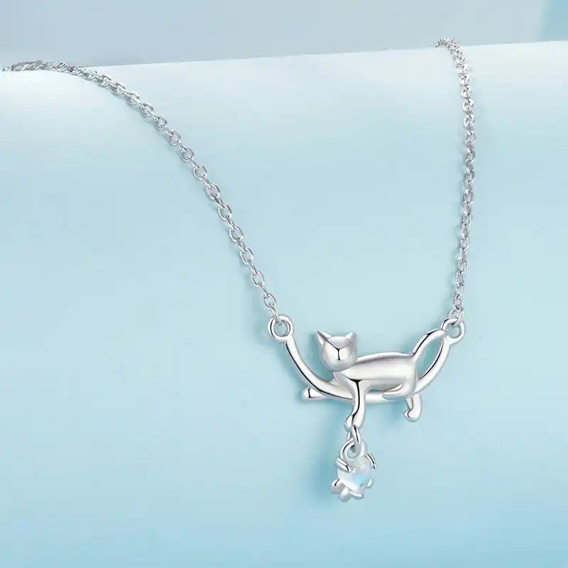Silver cat-shaped pendant necklace on a light blue background
