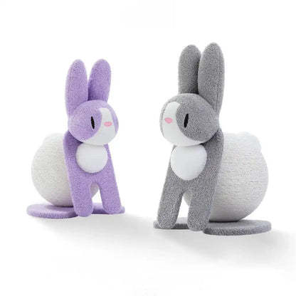 Two bunny-shaped cat scratchers, one purple and one gray, standing on a white background.