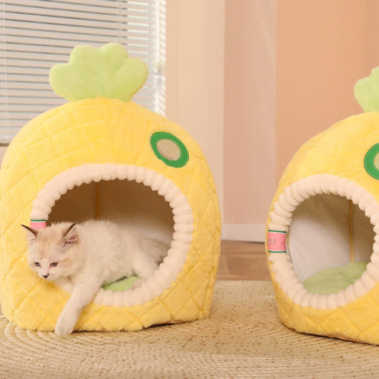 Two pineapple-shaped cat beds with a cat inside one of them on a wooden floor.