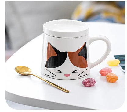 Cat-shaped mug with a spoon and candies on a white surface