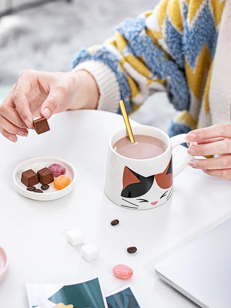Person adding chocolate to a mug of hot chocolate with a cat-themed mug.