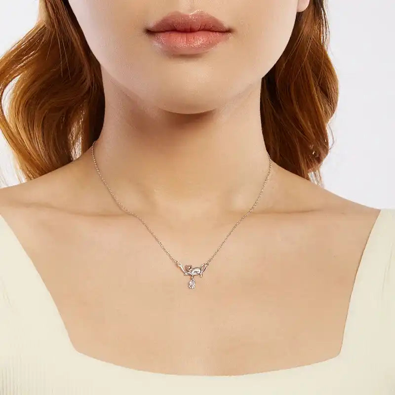 Necklace with a cat-shaped pendant worn by a person on a plain background