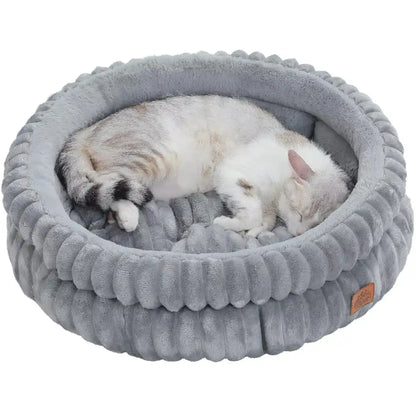 Cat sleeping in a gray ribbed cat bed with a white background