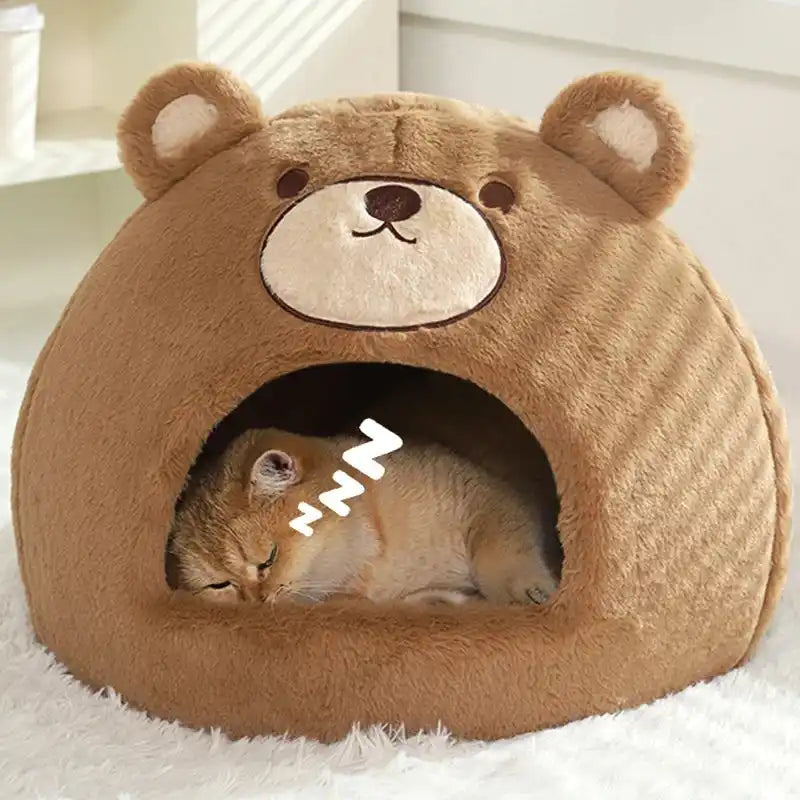 Cat lying inside a brown bear-shaped pet bed on a white surface.